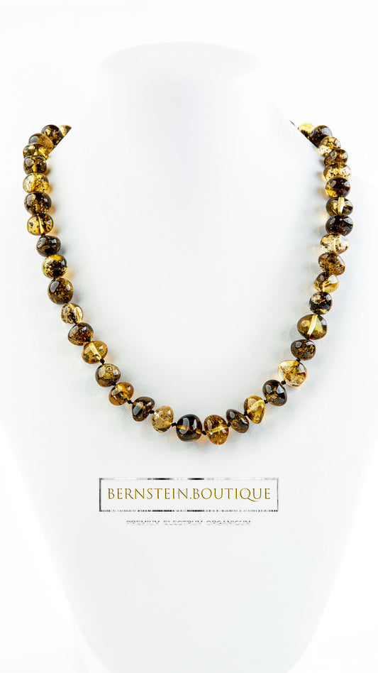 Necklace made of woody-greenish, polished baroque-shaped amber beads.