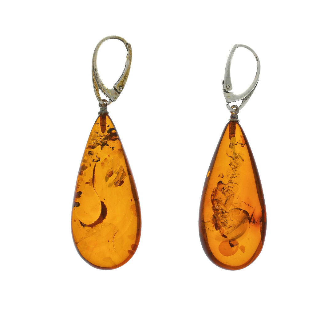 Drop Earrings: Nordic Natural Amber Teardrops on Sterling Silver 925
These striking drop earrings feature large, elegantly polished teardrops of pure Nordic natural amber, suspended from sturdy Sterling Silver 925 lever-back ear wires. The amber's transparency reveals captivating natural inclusions, rendering each pair distinctively unique. These earrings are an embodiment of timeless natural connection, imparting a warm, organic allure to any ensemble.